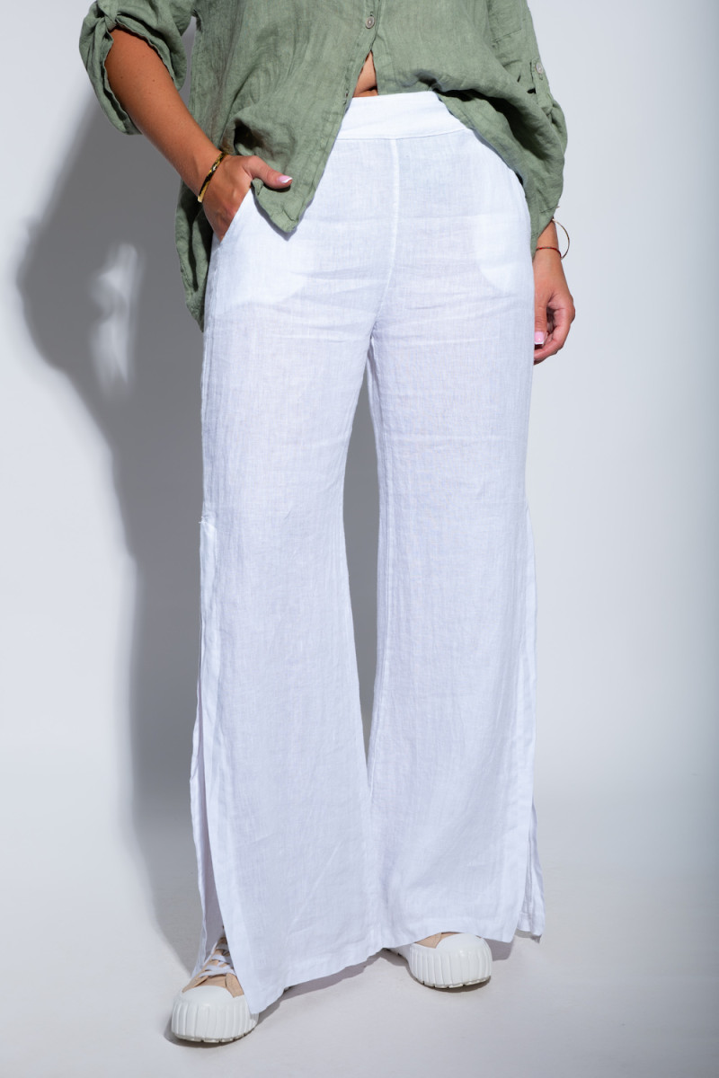 Белые льняные брюки с карманами и разрезами в низу штанин