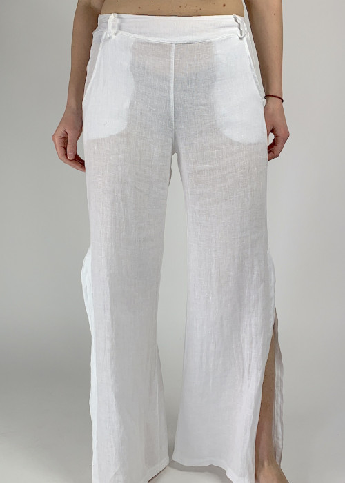 Белые льняные брюки с карманами и разрезами в низу штанин