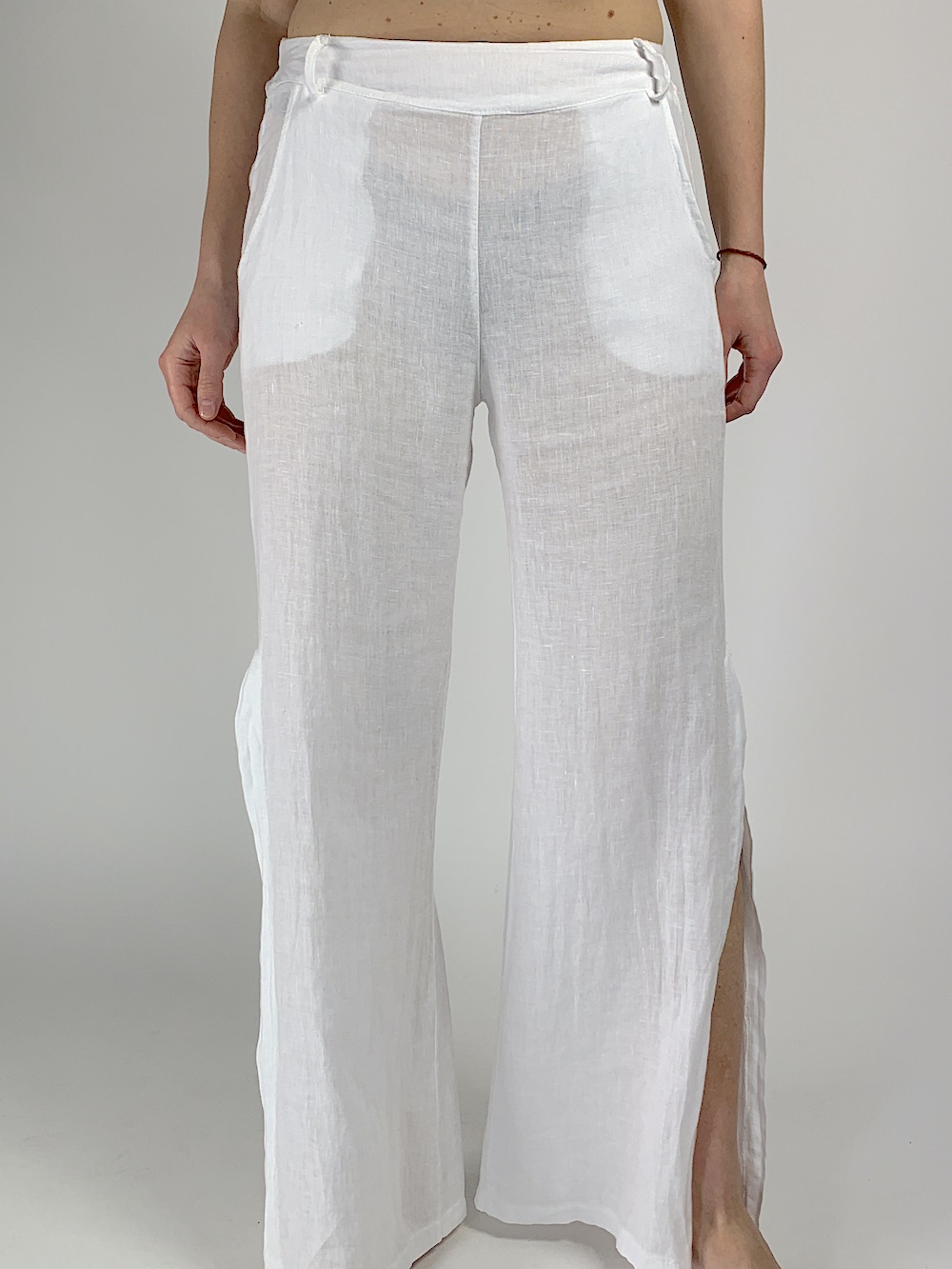 Білі лляні брюки з кишенями та розрізами на штанинах 